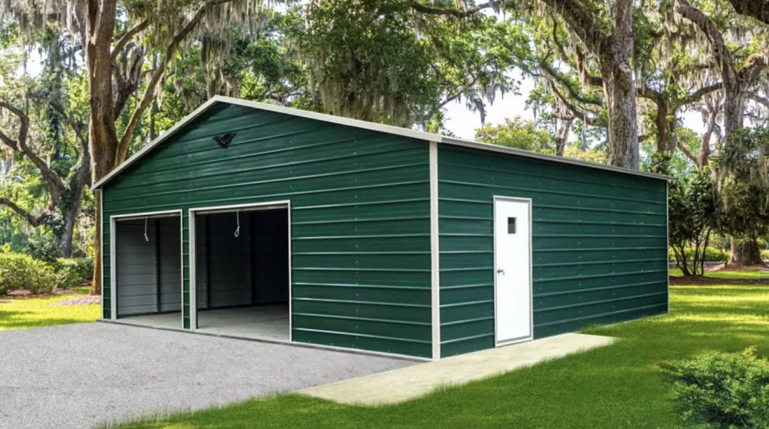 Green metal garage with two roll up doors and a walk in door